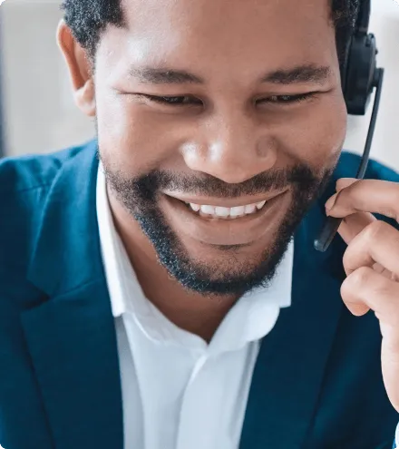 Profissional de atendimento sorrindo durante uma ligação com headset.