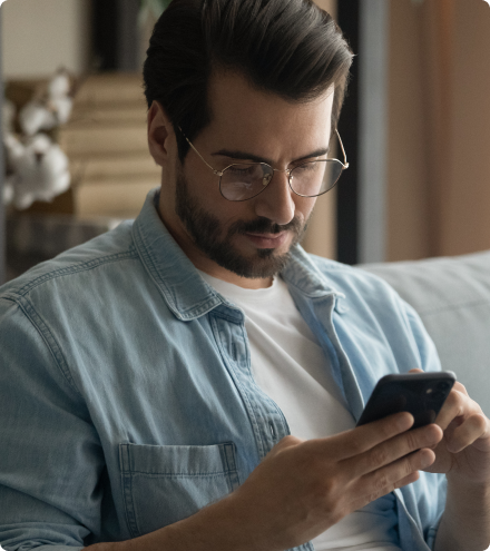 Homem consultando informações no smartphone em casa.