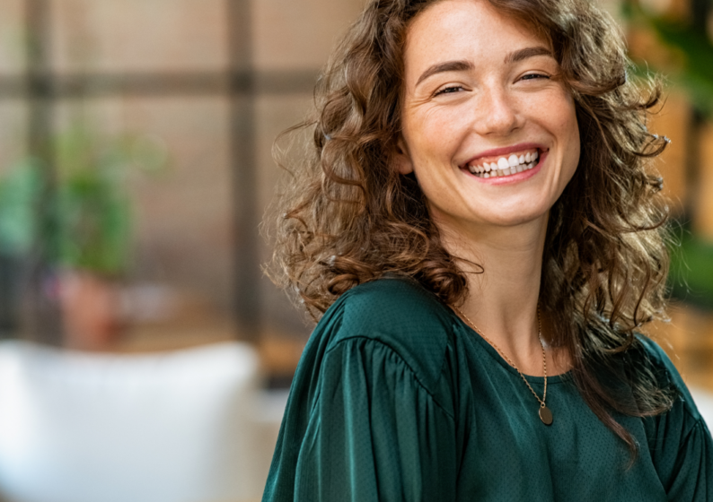 Mulher jovem sorrindo em ambiente de trabalho.
