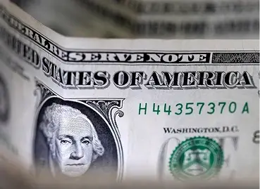 Close-up de cédula de dólar americano mostrando texto "Federal Reserve Note" e "United States of America", retrato de George Washington e número de série em cor verde